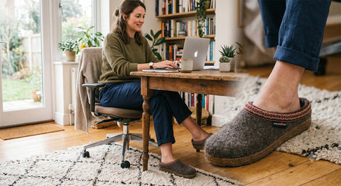 Frau arbeitet im Homeoffice mit grauen Haflinger Hausschuhen aus Wollfilz